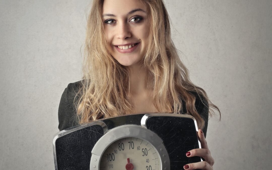 A woman holding a weighing scale